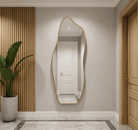 Full-length asymmetrical wall mirror with a sleek thin gold frame, mounted in a modern minimalist entryway hallway