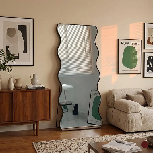 Living room with a large floor mirror, sofa, and decorative items.