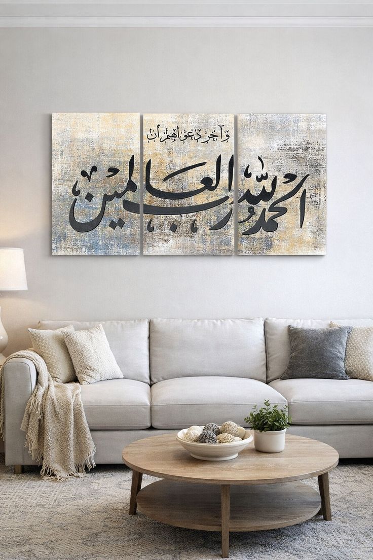 Three-panel Alhamdulillahi Rabbil Alamin in Arabic text wall art displayed above a modern living room sofa, featuring neutral grey, beige and gold abstract textured artwork.