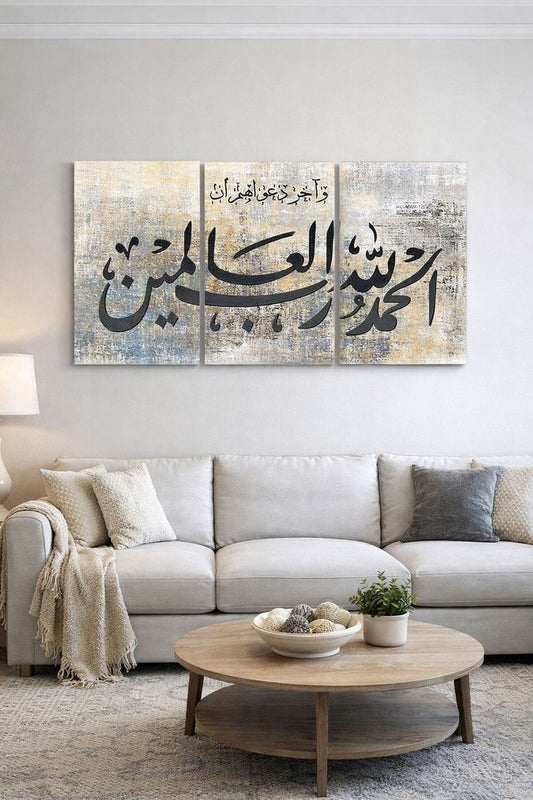 Three-panel Alhamdulillahi Rabbil Alamin in Arabic text wall art displayed above a modern living room sofa, featuring neutral grey, beige and gold abstract textured artwork.