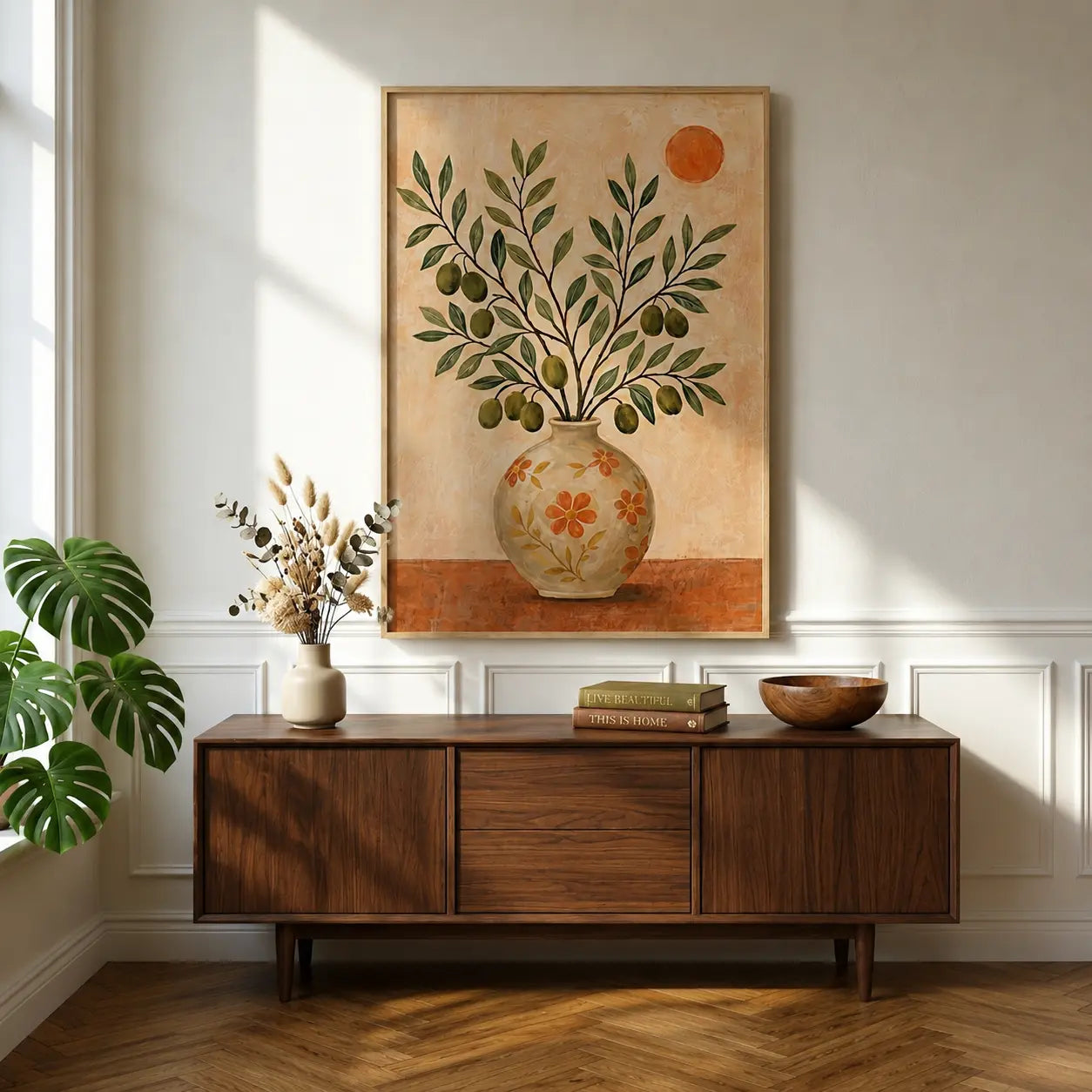 Warm botanical wall art featuring leaf branches, floral details and a decorative vase in a wooden frame, styled with neutral modern furniture.