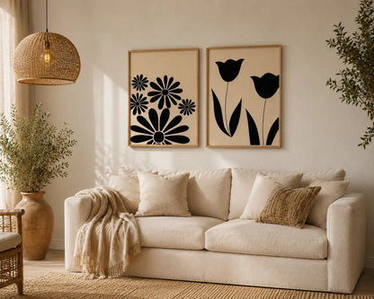 Floral wall art for bedroom set of 2 featuring black daisy and tulip silhouettes in wooden frames above a bed by Decorsz Pakistan.