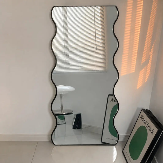 Modern full-length standing mirror with unique wavy frame for bedroom interior